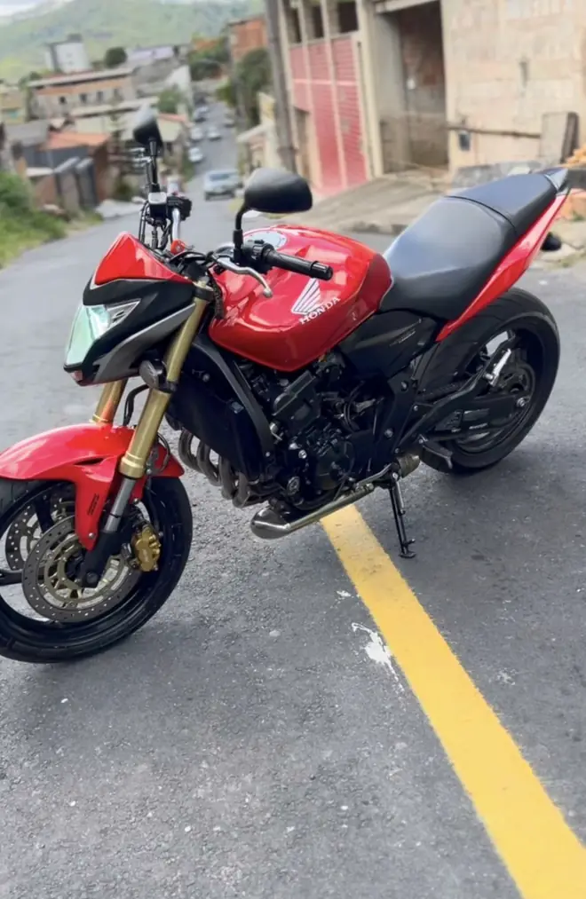 Moto vermelha com garfo dourado na rua