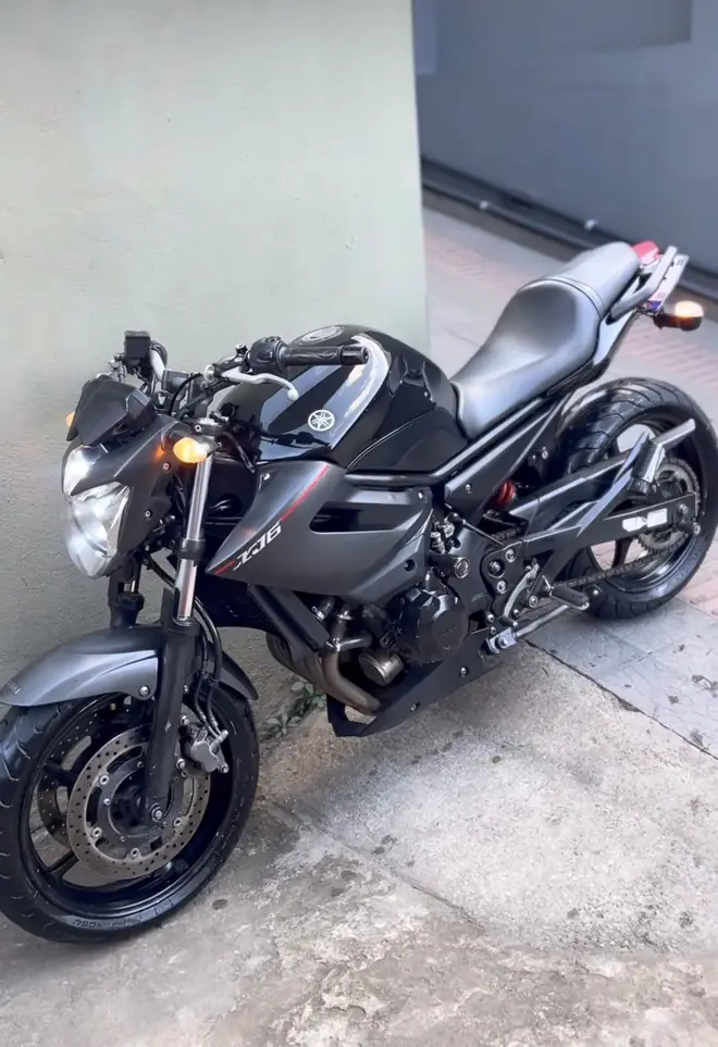 Moto naked preta ao lado de uma parede