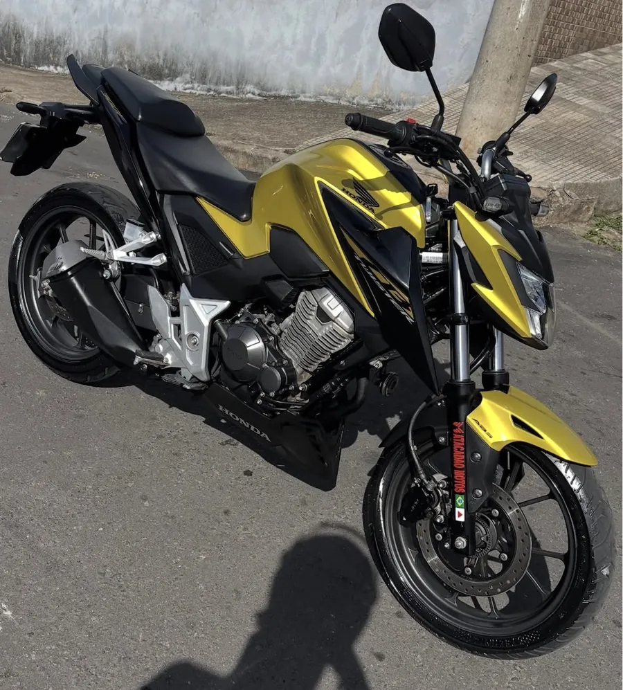 Moto naked amarela e preta estacionada na rua